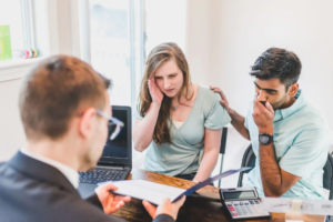 Homebuyers reviewing inspection report with concerned expressions and inspector.